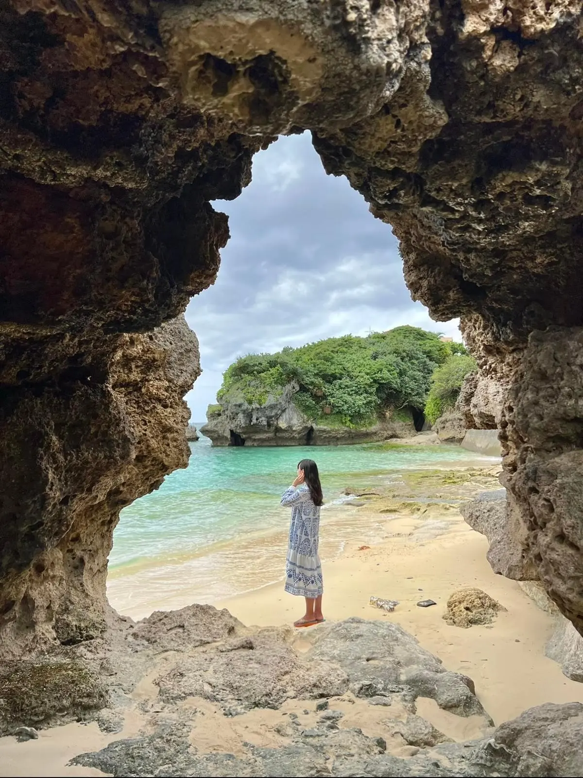 古宇利島　チグヌ浜の「始まりの洞窟」にいる女性