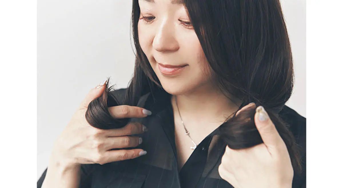 髪の毛先にヘアオイルをなじませている女性
