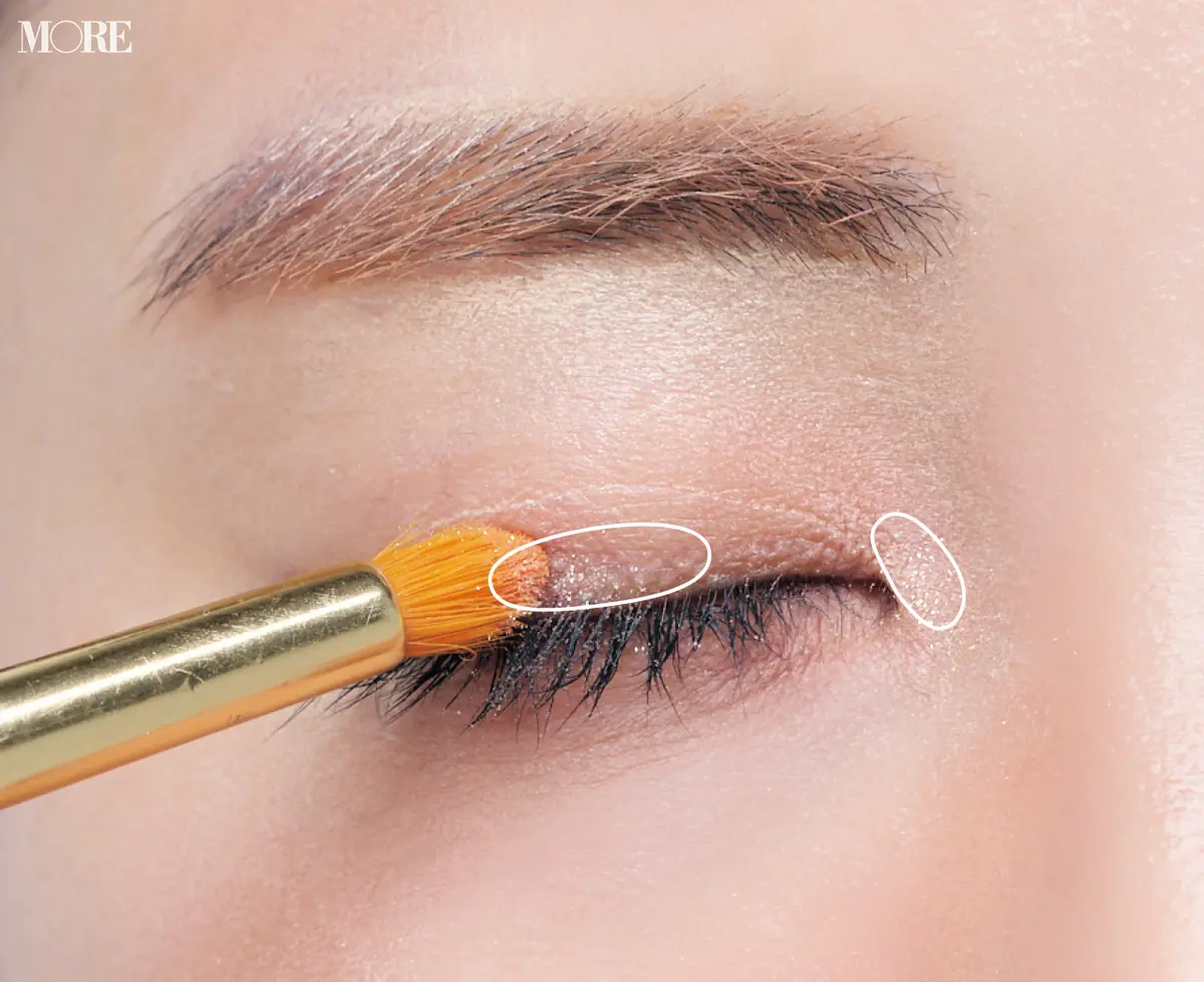 ラメ入りアイシャドウがついたブラシを目の上に置いた目元