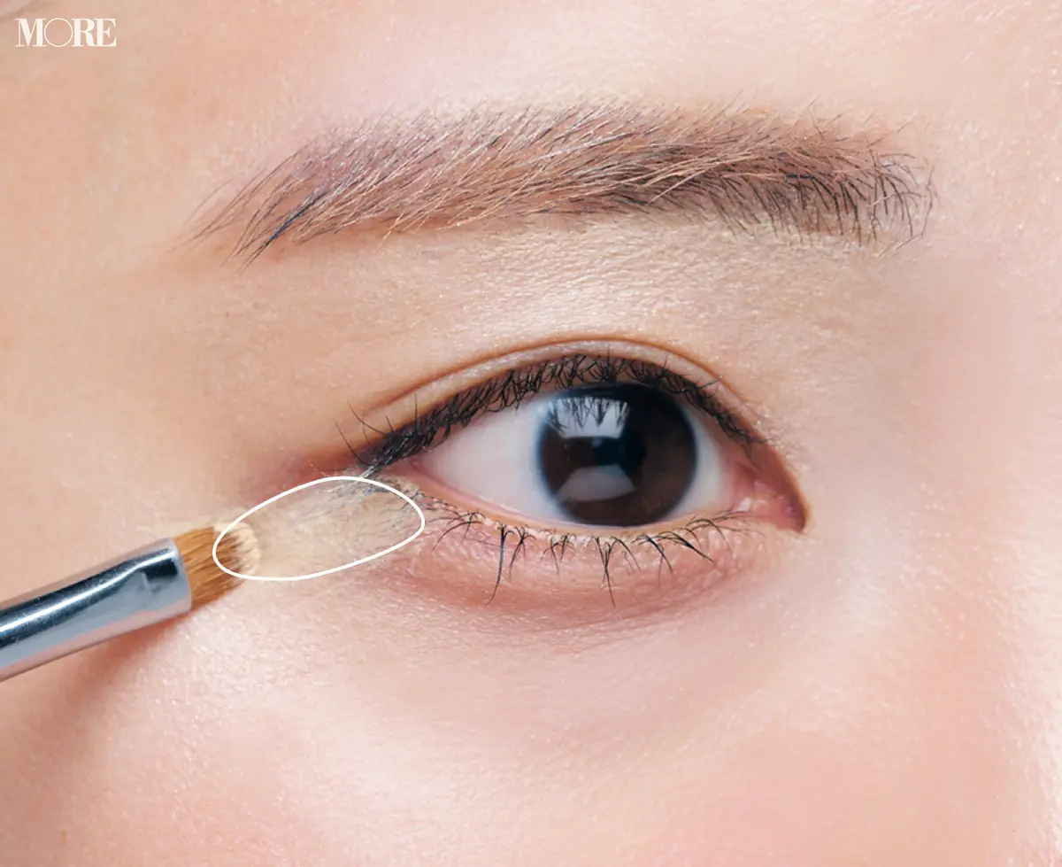 コンシーラーをつけたブラシを目尻においた目元