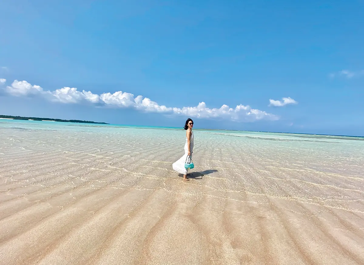 鹿児島県　ヨロン島 百合ヶ浜の海にいる女性　晴れの空