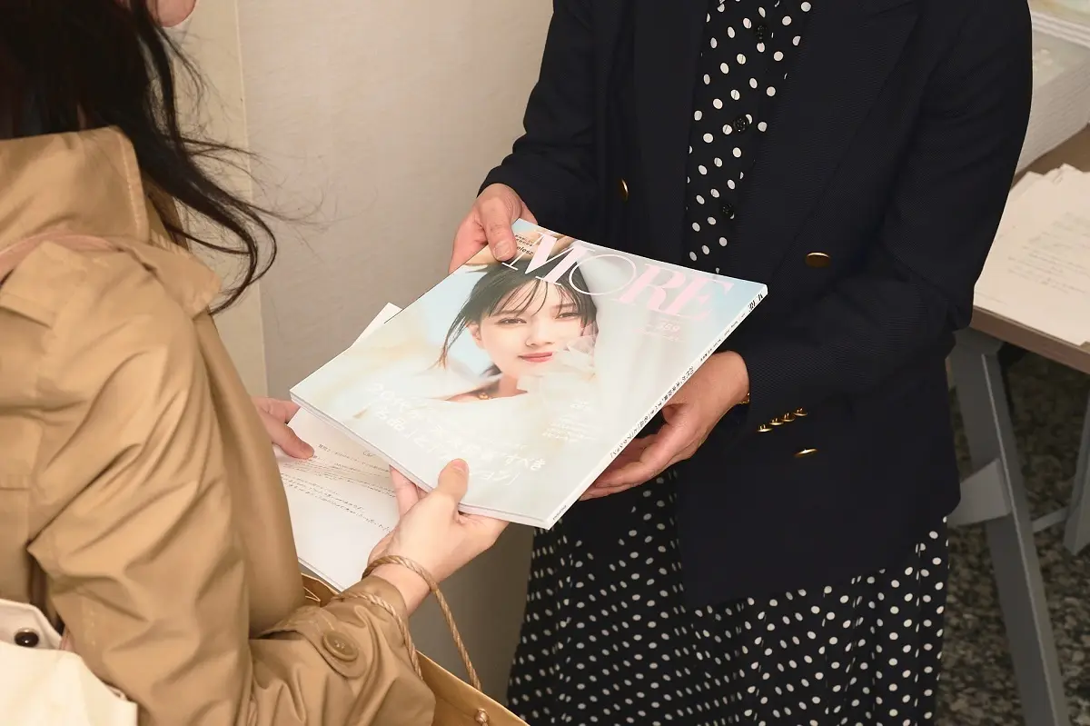 MOREWEB編集長・中田が来場者にMORE最新号を手渡しする様子