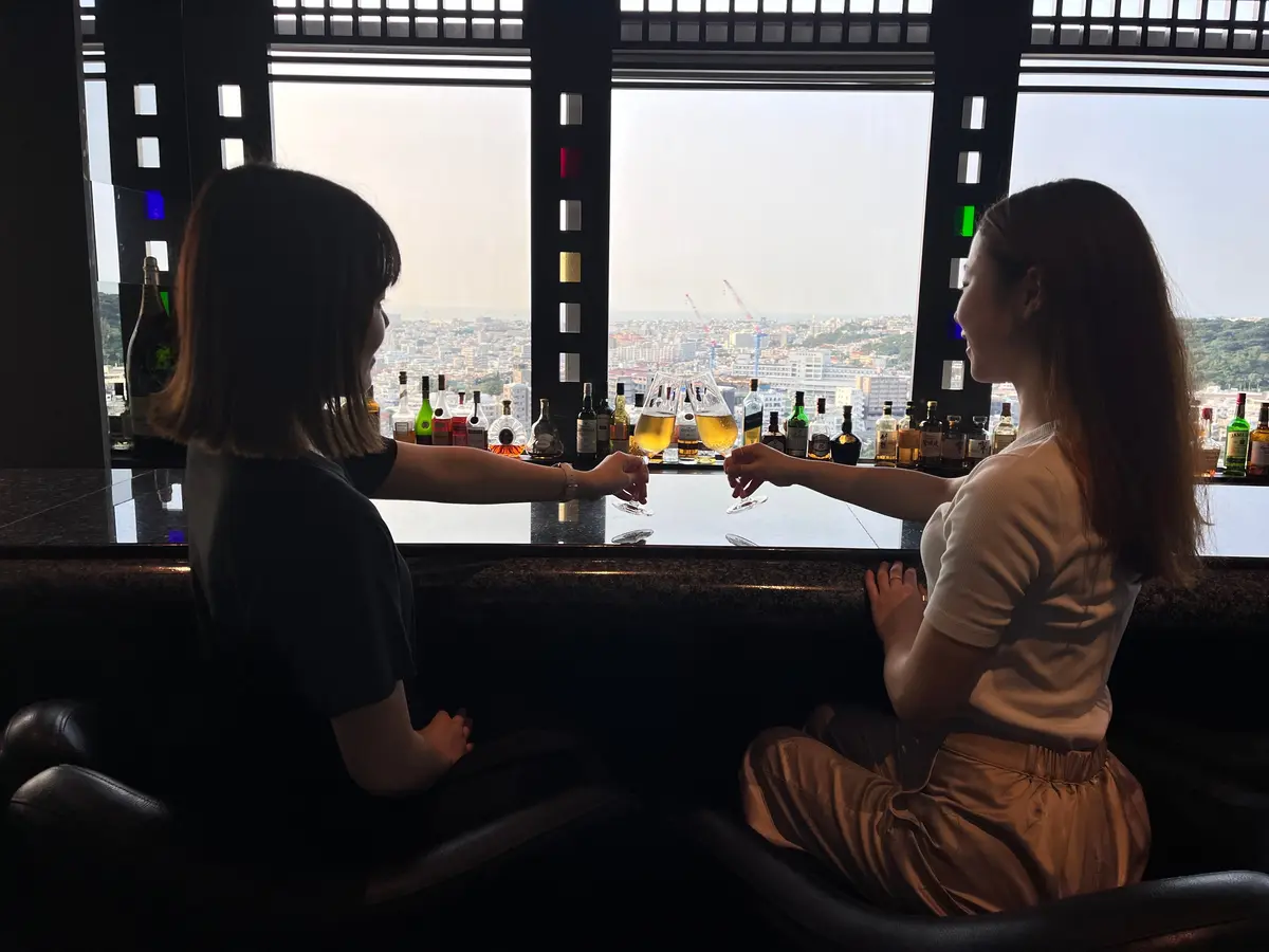 「ダブルツリーbyヒルトン那覇首里城」サンセットラウンジのカウンターに座る2人の女性