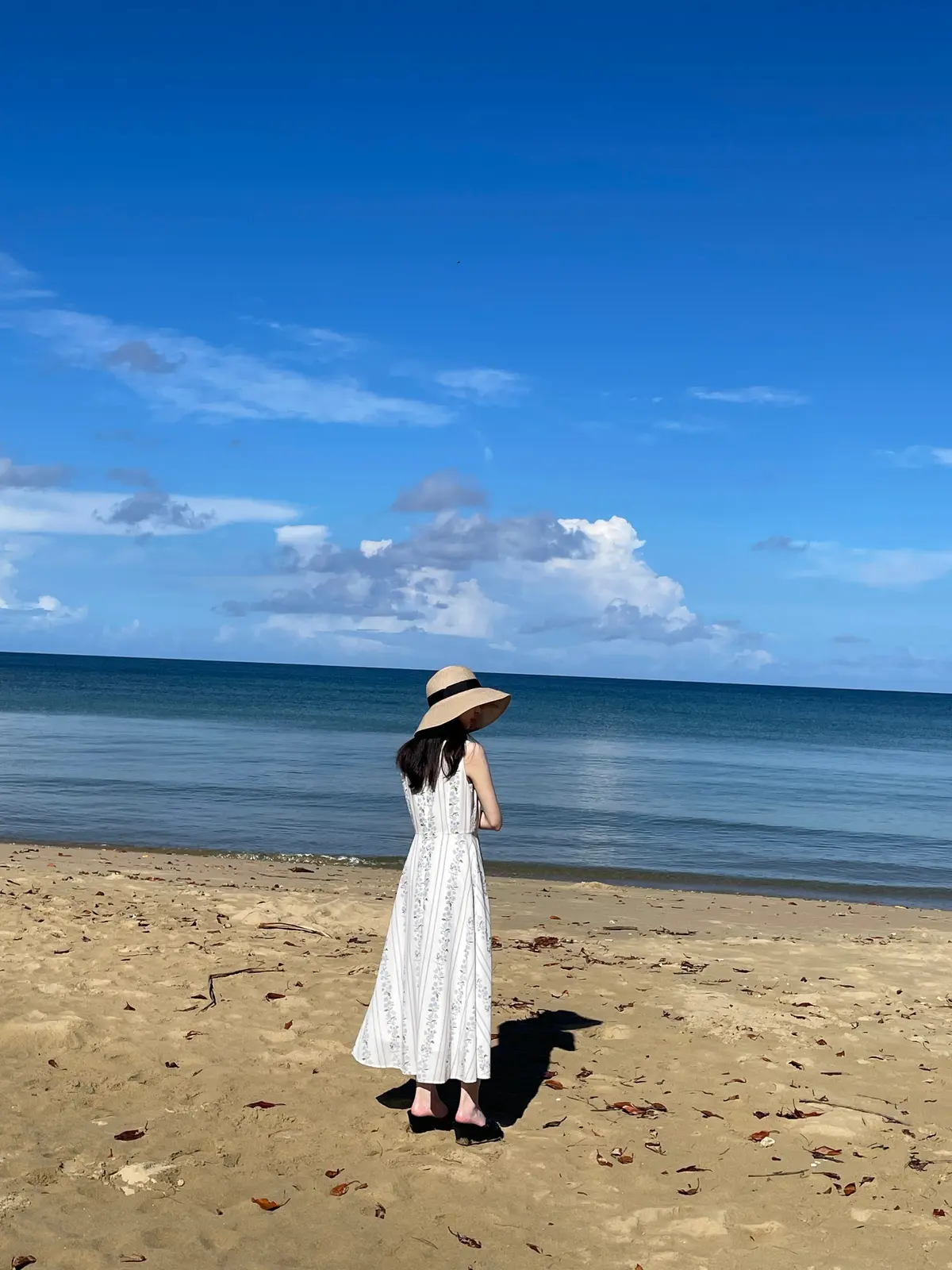 海を前に立つ女性