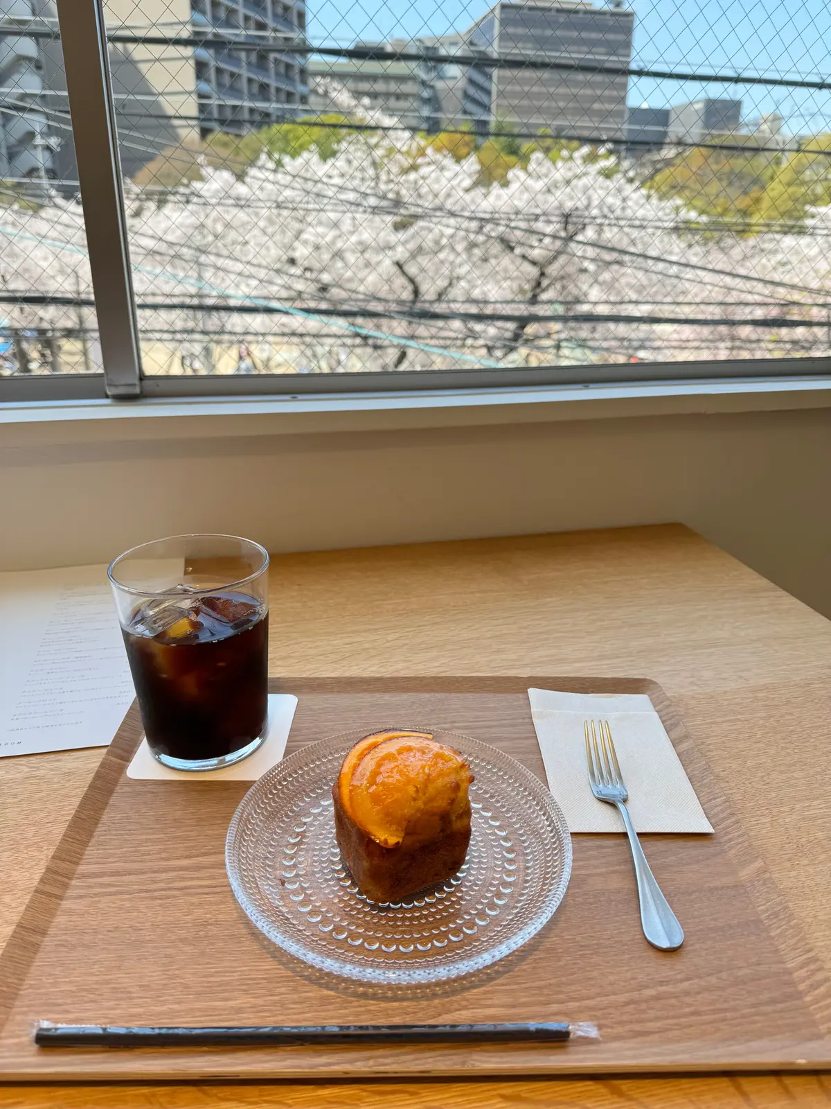 オレンジケーキとアイスコーヒー　桜が見える窓