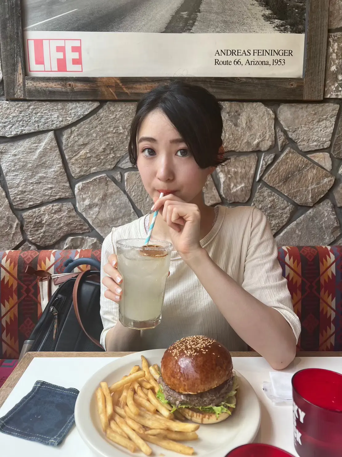 ザ　グレートバーガー　自家製レモンソーダを飲む女性