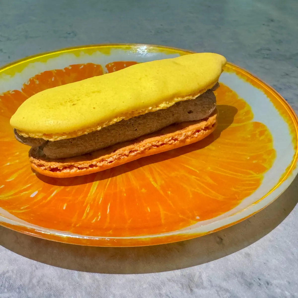 ファミリーマート「マカロン サンド（チョコレート＆パッション パイン）」を皿に乗せた様子