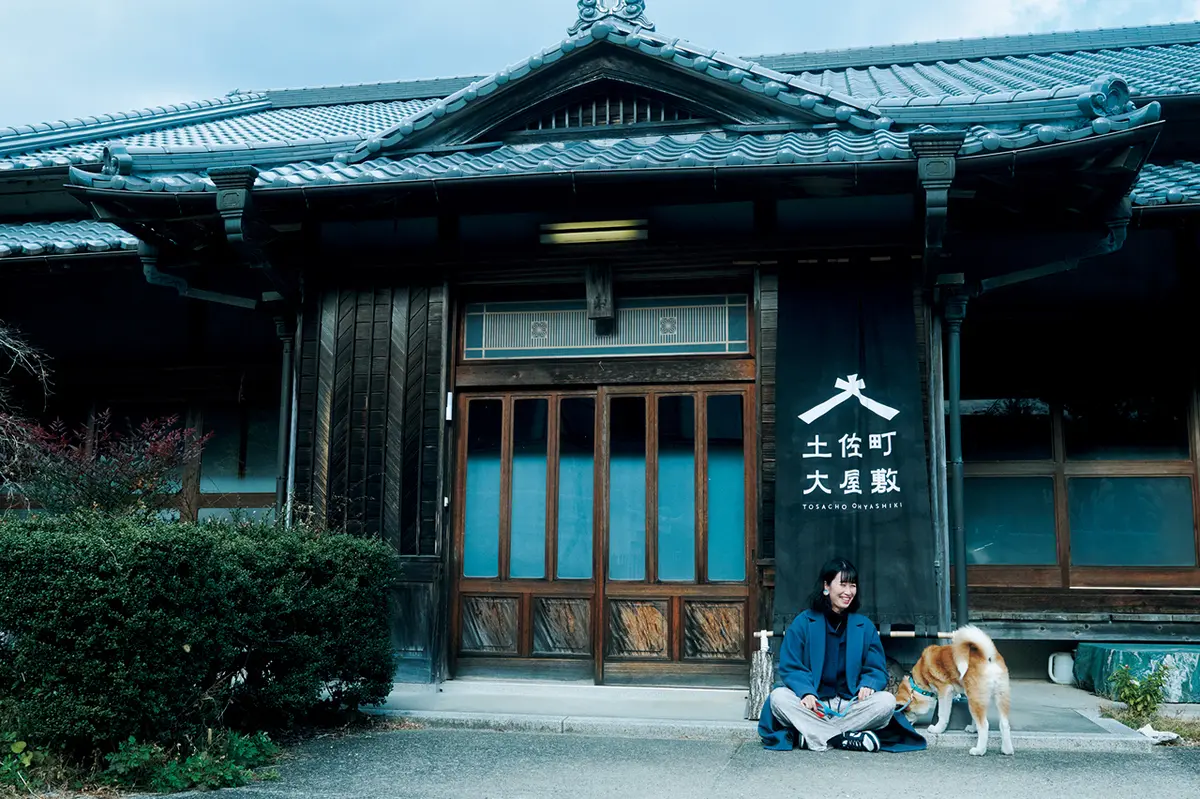 『土佐町大屋敷』の前に座る女性