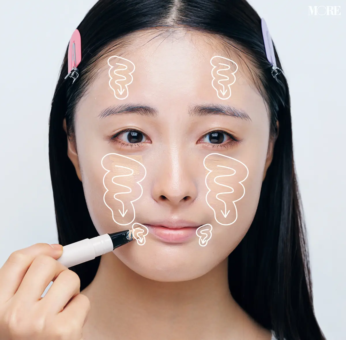 ベージュの下地を顔中心の脇に塗るモデル