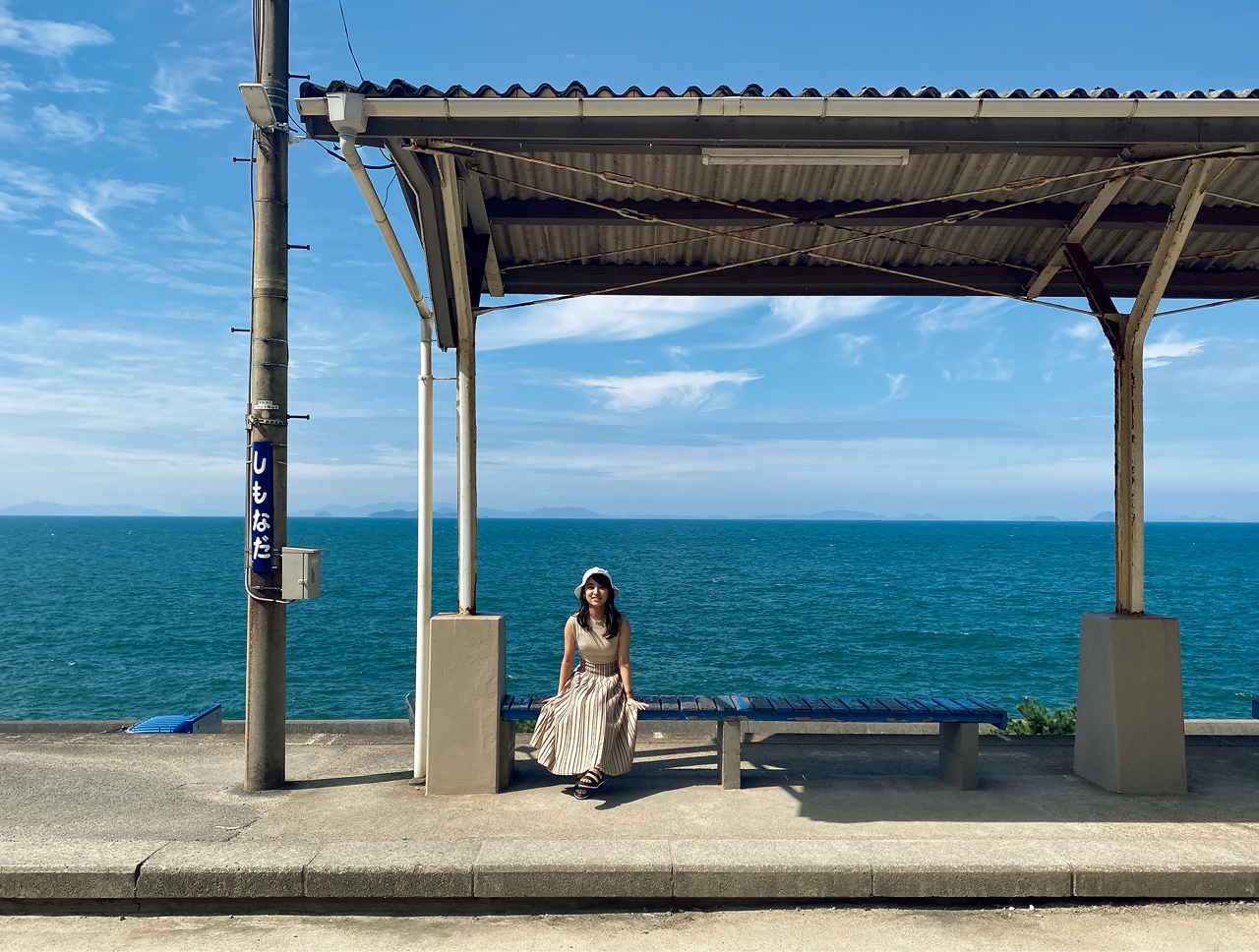 愛媛県の下灘駅のベンチに座る女性